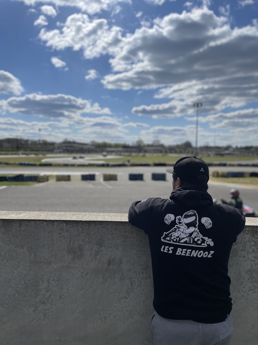 Un membre de l'équipe en sweat Les Beenooz regarde la piste